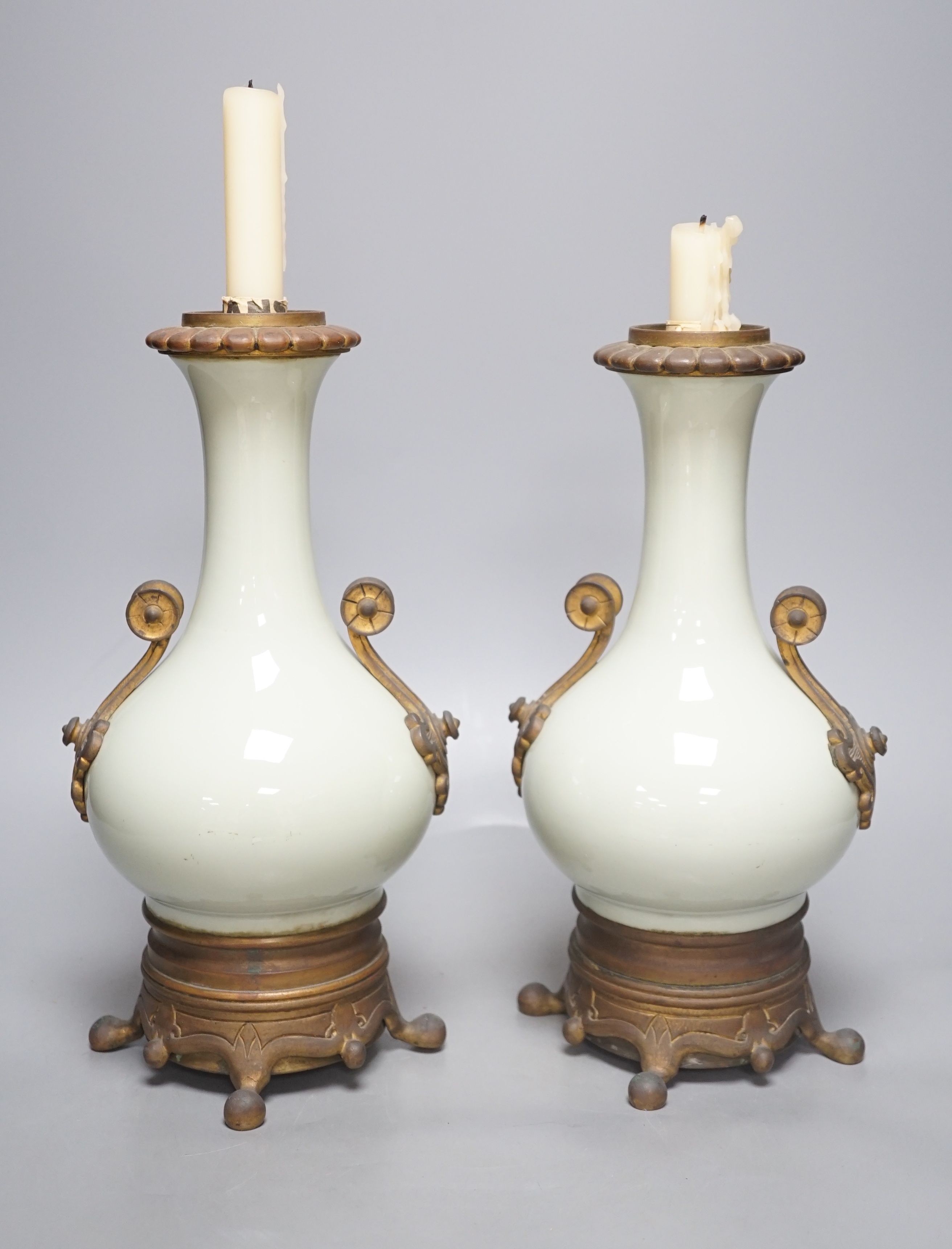 A pair of French celadon ground vases, now used as candlestands, total height 30cm